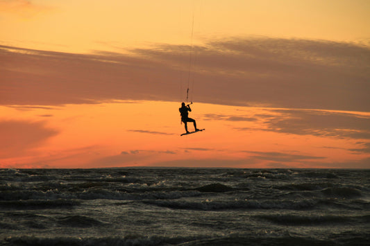 Kiteboarder soaring in the sunset sky